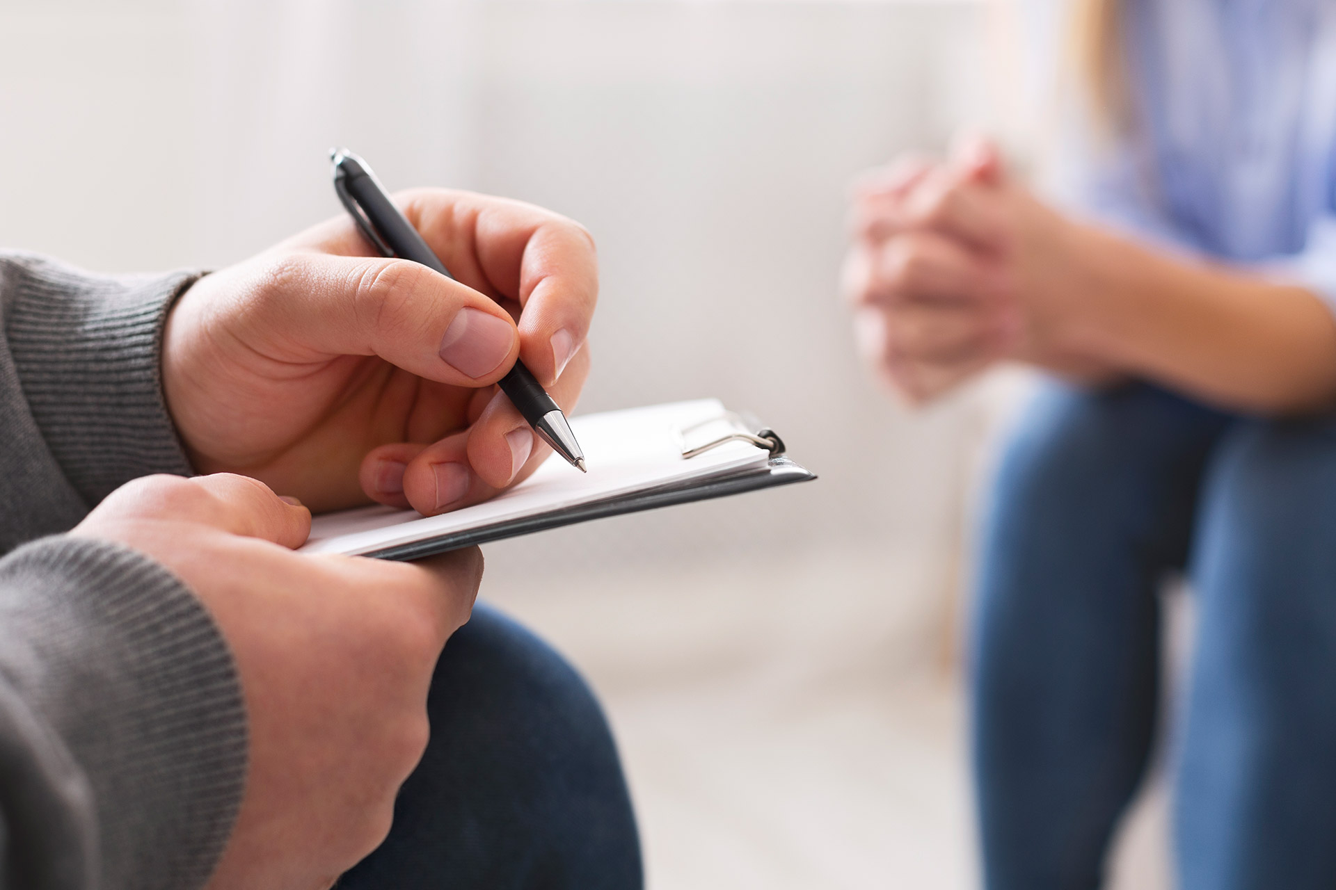 Psicóloga tomando notas durante una sesión de terapia